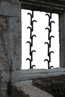 Ancient Stone Windowwith Iron Bars PNG image