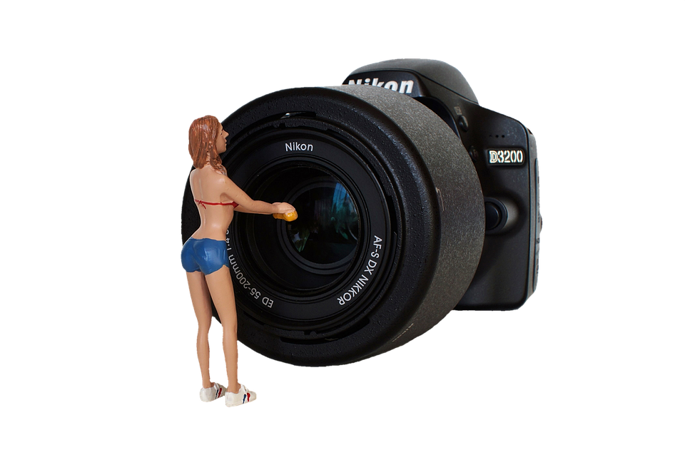 Miniature Figure Cleaning Nikon D3200 Lens PNG image