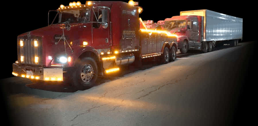 Nighttime Tow Truck Hauling Semi Trailer PNG image