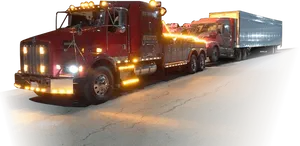 Nighttime Tow Truck Hauling Semi Trailer PNG image