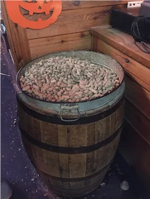 Whiskey Barrel Fullof Peanuts Halloween Decor PNG image