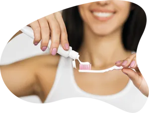 Woman_ Applying_ Toothpaste_ On_ Toothbrush PNG image